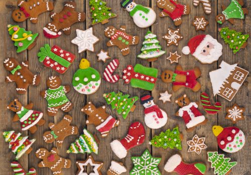 This image features a variety of decorated Christmas cookies, including shapes like trees, snowmen, gingerbread men, Santa, and festive ornaments.