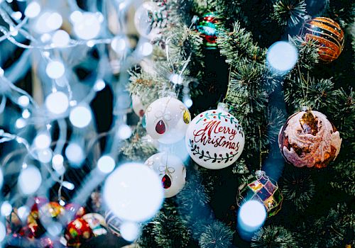 A decorated Christmas tree with various ornaments, including a 