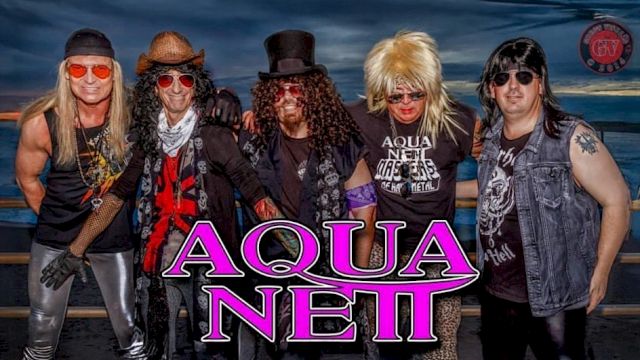 The image shows five people dressed in glam rock style with the text "Aqua Netl" in bold letters overlaid on the image.