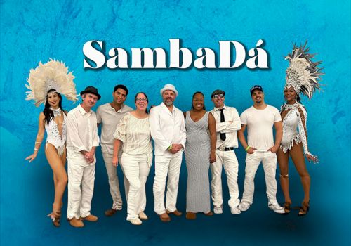 A group of people dressed in white, standing in front of a blue background with the word 