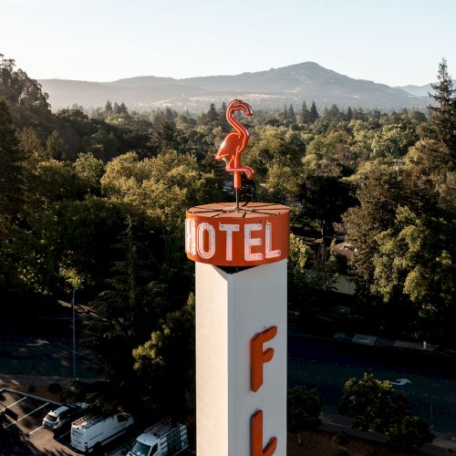 The image shows a cylindrical motel sign with a red flamingo on top and the word 