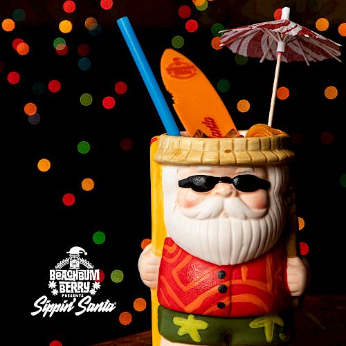 A festive Santa-themed cocktail with colorful straws and an umbrella. Text reads 