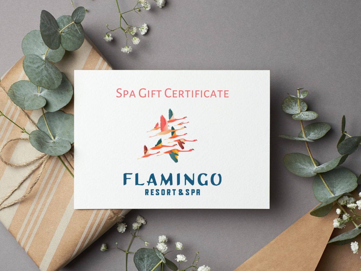 A spa gift certificate from Flamingo Resort & Spa is placed with wrapped gifts and greenery on a gray background.